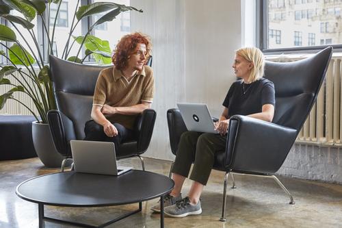 Two people working together on laptops.