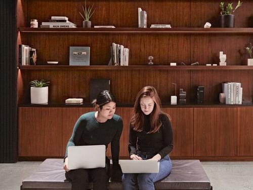 Two people sitting with laptops