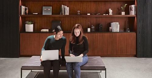 Two people sitting with laptops