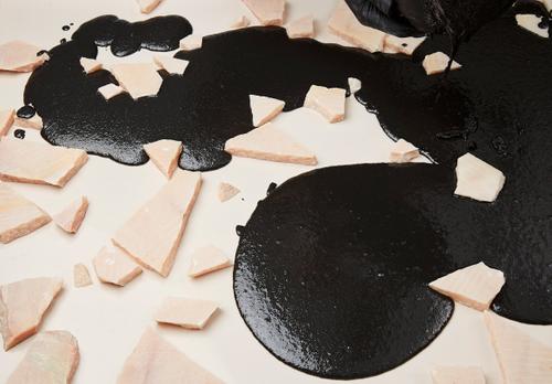 Black concrete being poured into terrazzo mold