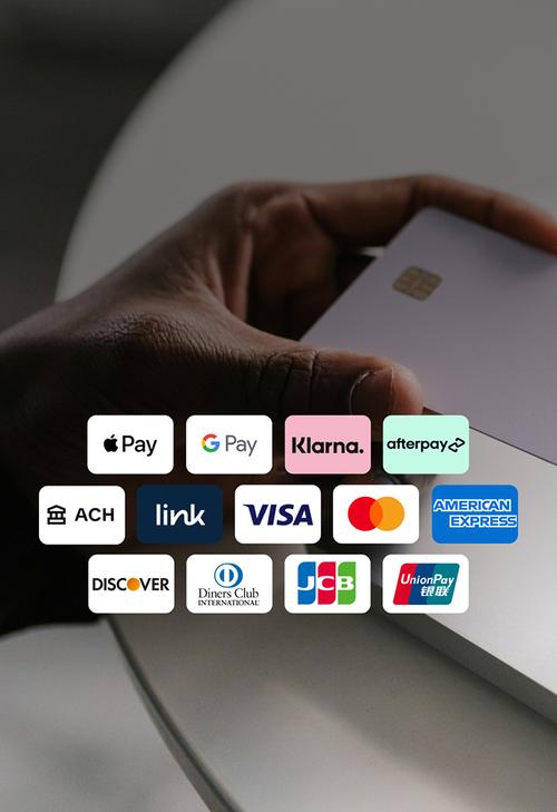 Mano que sostiene una tarjeta de pago blanca cerca del teclado de una computadora portátil. La superposición muestra una cuadrícula de los métodos de pago aceptados.