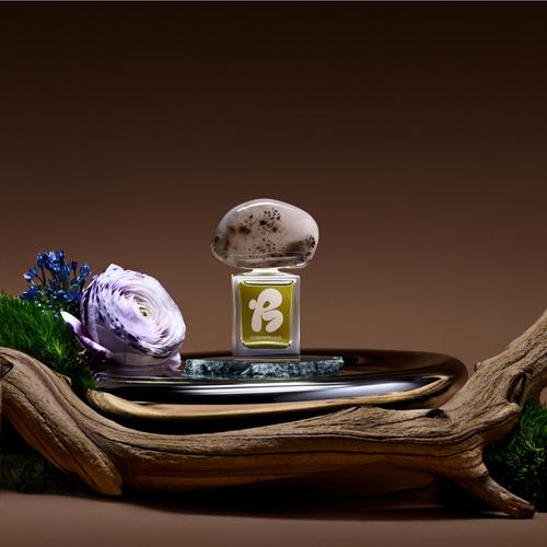 Un flacon de parfum artisanal présenté à côté d’un avis sur le produit de la part d’un client parlant de son expérience d’achat dans une boutique de produits de beauté en ligne.