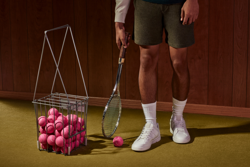 Personne tenant une raquette de tennis et un panier rempli de balles de tennis roses