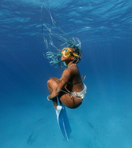 Gabby Shepard, founder of Black Girl Blue World, swimming underwater with fins.