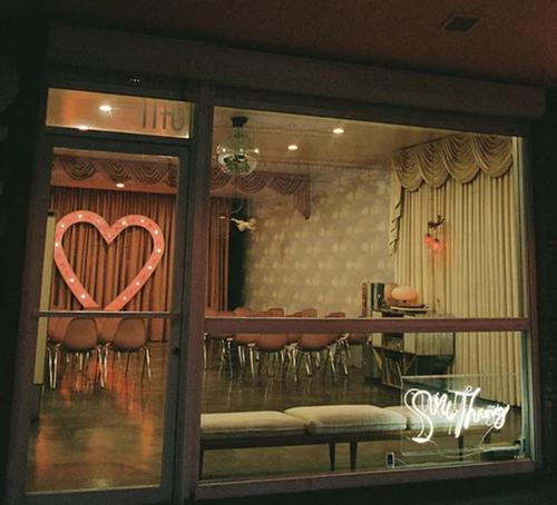 Interior view of Sure Thing Chapel, a wedding venue with a heart-shaped window and warm lighting.