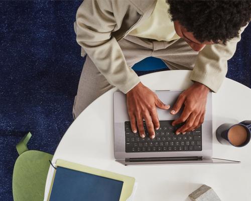 Hand holding pen over desk