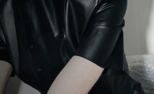 Closeup of person wearing a black leather shirt